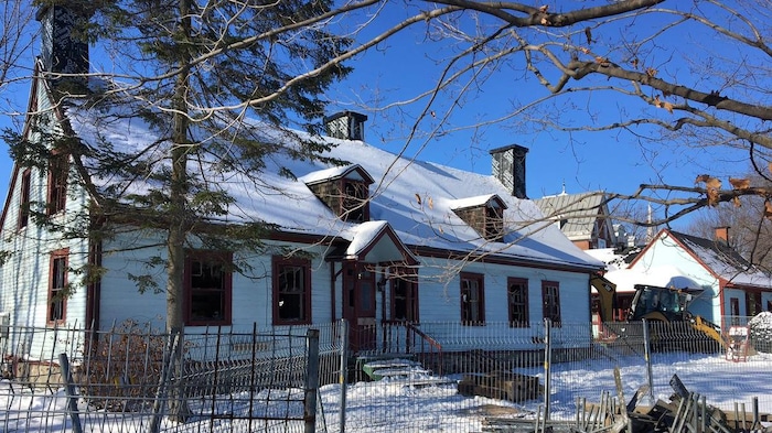La maison est ceinturée d'une clôture de métal.