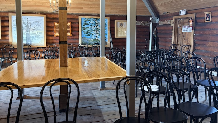 La table au centre de la maison Chaboillez et les nombreuses chaises noires autour qui ont placées là pour la conférence de presse de la 57e édition du Festival du Voyageur. 