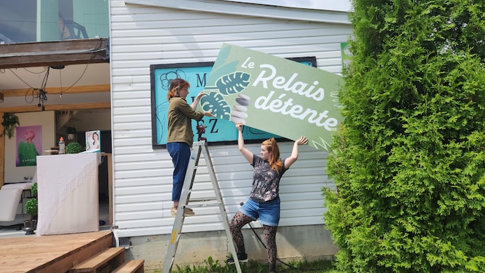Deux personnes changent une affiche pour une autre