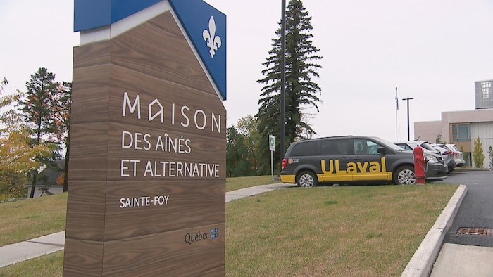 Photo extérieure de la Maison des aînés de Sainte-Foy avec dans le stationnement une voiture identifiée à l'effigie de l'Université Laval.