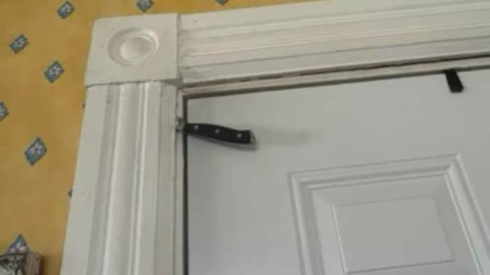 Un couteau planté dans un cadre de porte, de manière à bloquer l'ouverture de la porte.