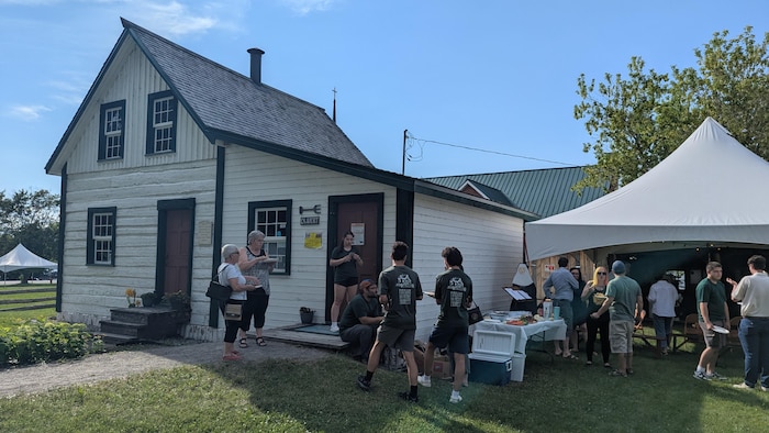 Des gens mangent d'un buffet dehors sur le terrain du musée.