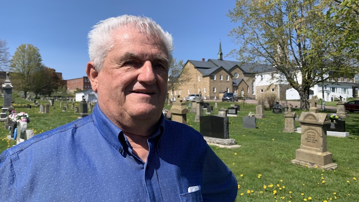 Léonce Dupuis devant un cimetière.