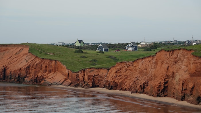 Des maisons avec des falaises de grès rouge en avant-plan.