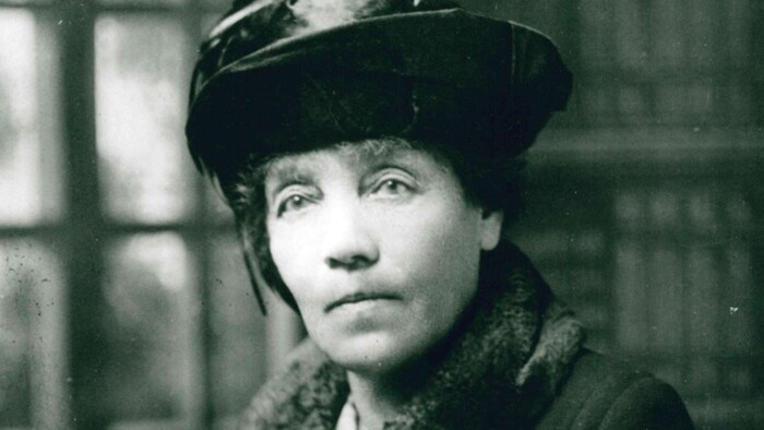 Un portrait d'époque en noir et blanc d'Isabella Lougheed avec un regard sérieux portant un chapeau de velours et un manteau avec un large col en fourrure. 