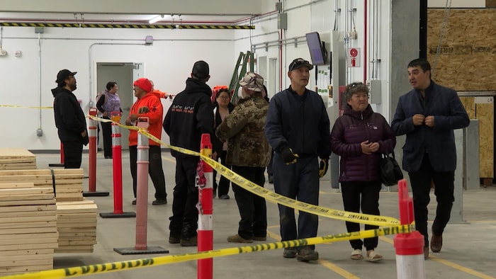 Un groupe de personnes marche dans l’usine de maisons préfabriquées à Arviat, au Nunavut.
