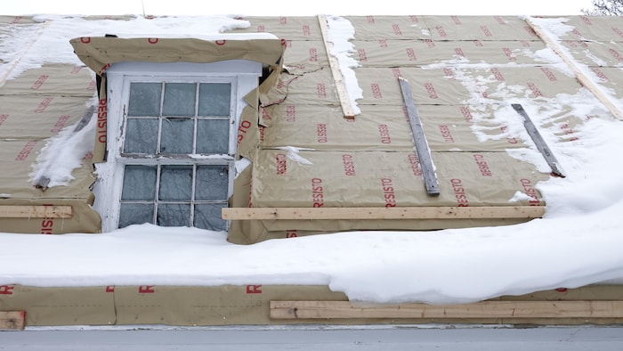Une toiture de maison en hiver en mauvais état.