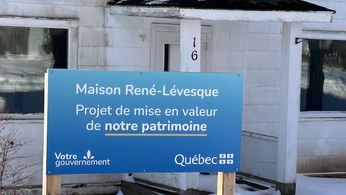 Une affiche du gouvernement du Québec où il est écrit «projet de mise en valeur de notre patrimoine» devant la maison.