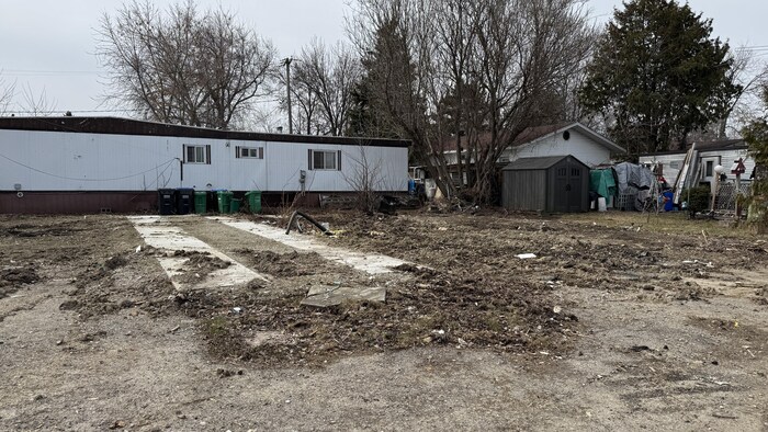 Un terrain vide à côté d'une maison mobile.