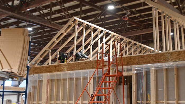 Des employés de Maisons Suprêmes travaillent sur la charpente d'une maison.