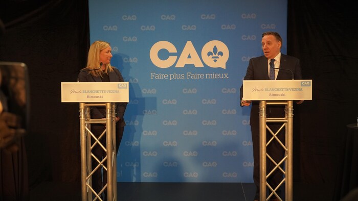 Un homme et une femme derrière des lutrins.
