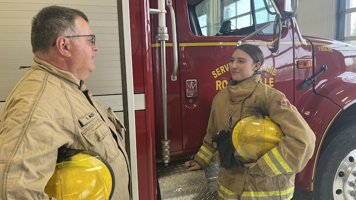 Makayla Gaudet et Yvon Hachey se tiennent devant un camion de pompier.