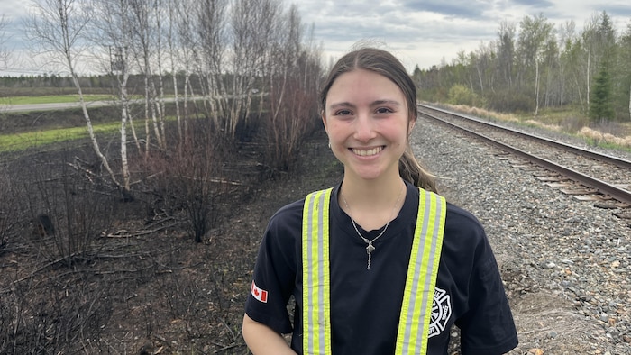 Makayla Gaudet pose pour la photo, devant le chemin de fer.