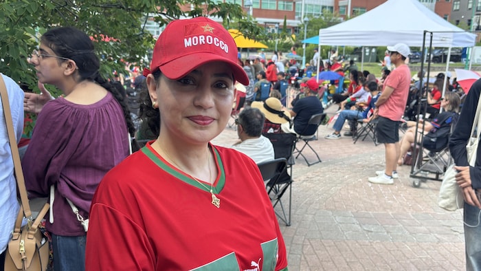 Une personne porte une maillot et une casquette de l'équipe de soccer du Maroc.