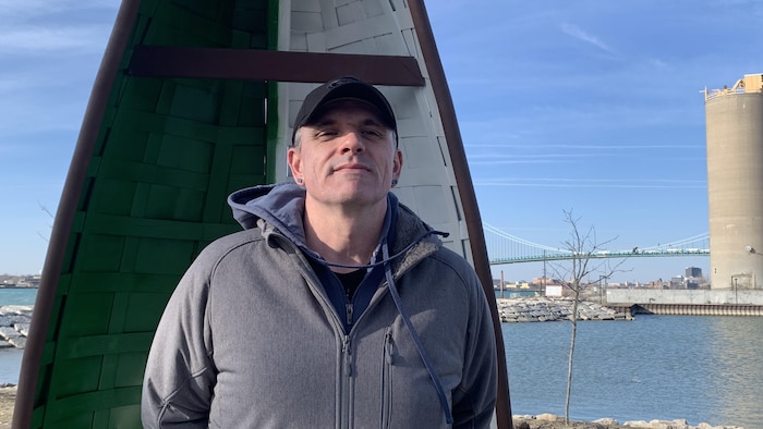 Un portrait de Danny Maltais devant l’œuvre.