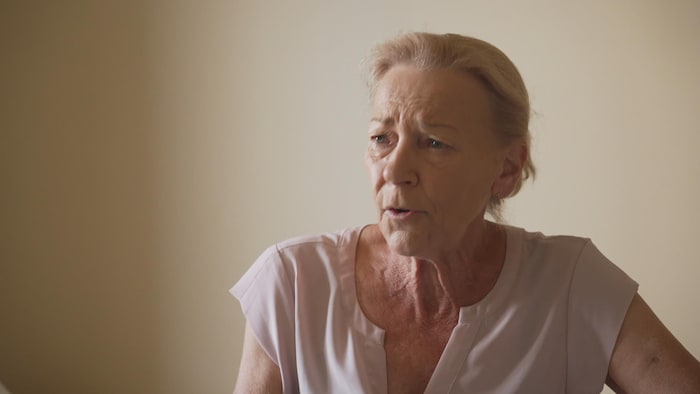 Elle répond aux questions dans un local.
