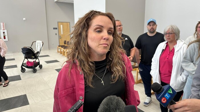 Malyssa Burns parle aux journalistes à l'extérieur de la salle d'audience, entourée de ses proches.