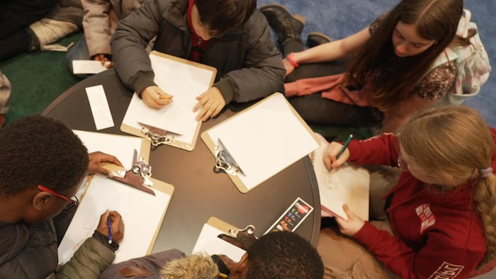 Des enfants dessinent durant un atelier sur les mangas. 