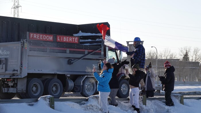 Des manifestants brandissent un drapeau au passage d'un camion.