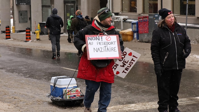 Une personne dans la rue avec une pancarte.