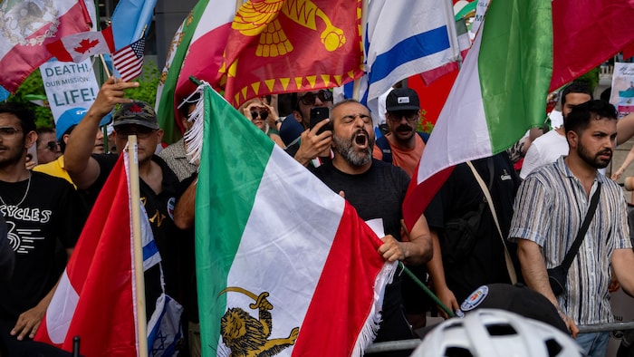 Plusieurs manifestants brandissent des drapeaux.