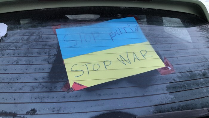 Une voiture avec une affiche à l'arrière.