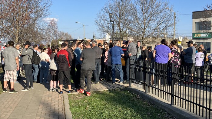 Plusieurs personnes attroupées sur une place publique.