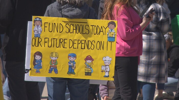 Une pancarte appelle en anglais à financer l'éducation pour garantir un meilleur futur aux élèves, le 29 avril 2023 à Regina.