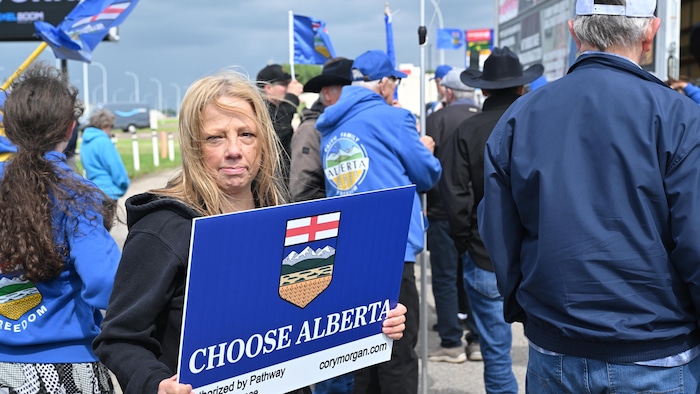 Une manifestante brandit une pancarte qui appuie l'indépendance de l'Alberta 