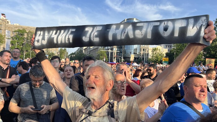 Un manifestant porte une banderole critiquant le président serbe, à Belgrade. 