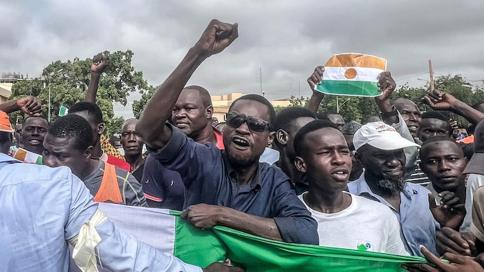 Des manifestants tiennent des drapeaux du Niger.