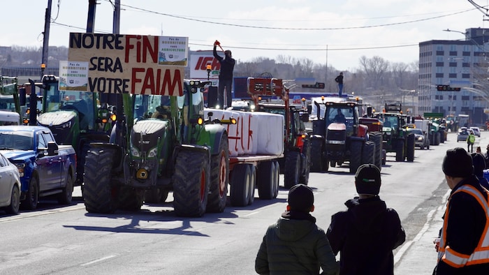 «Notre fin sera votre faim», affichent sur des pancartes plusieurs tracteurs venus manifester à Rimouski, le 8 mars 2024.