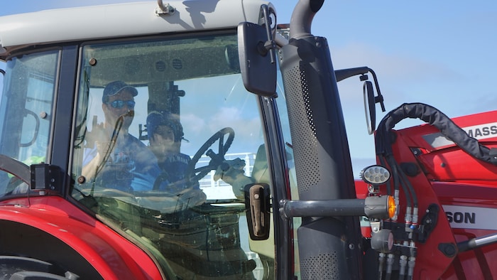 Un agriculteur et un enfant dans un tracteur.