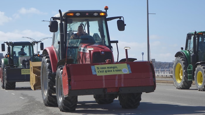 Un agriculteur dans son tracteur, sur le boulevard René-Lepage à Rimouski, dans une manifestation le 8 mars 2024.