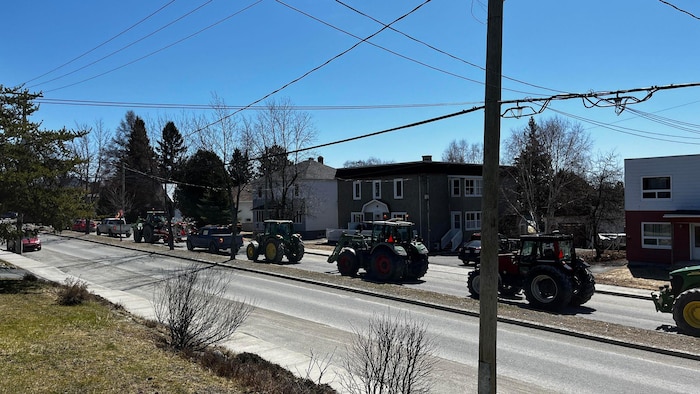 Plusieurs tracteurs sur une rue.