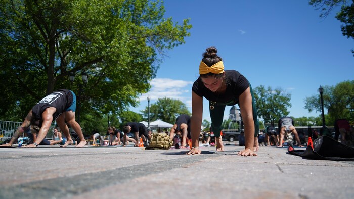 Une jeune femme fait la planche entourée de yogis. 