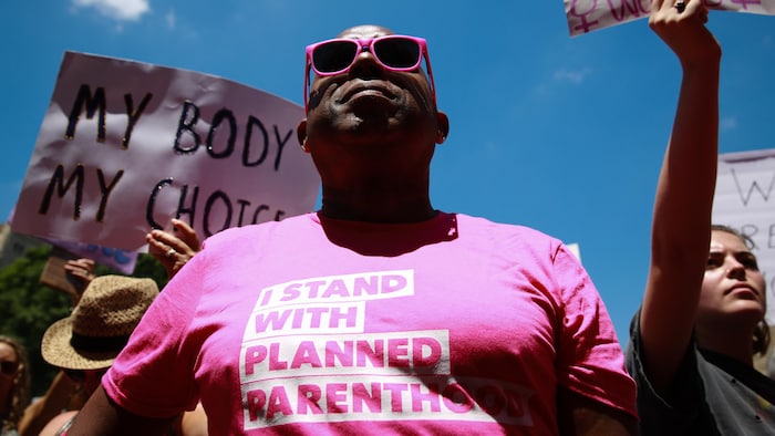Un manifestant américain pro-choix porte un gaminet rose sur lequel il est écrit, en anglais : « Je soutiens Planned Parenthood ».