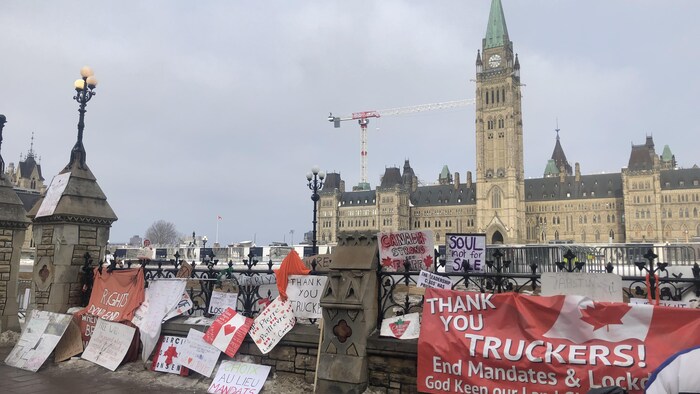 Des drapeaux et des affiches lors d'une manifestation devant le parlement à Ottawa