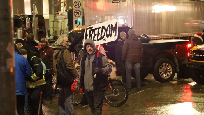 لقطة من الاحتجاجات المتواصلة لسائقي الشاحنات وسائر المتظاهرين ضد الإجراءات الصحية في أوتاوا اليوم، ويبدو أحدهم حاملاً لافتة كُتب عليها ’’حرية‘‘.