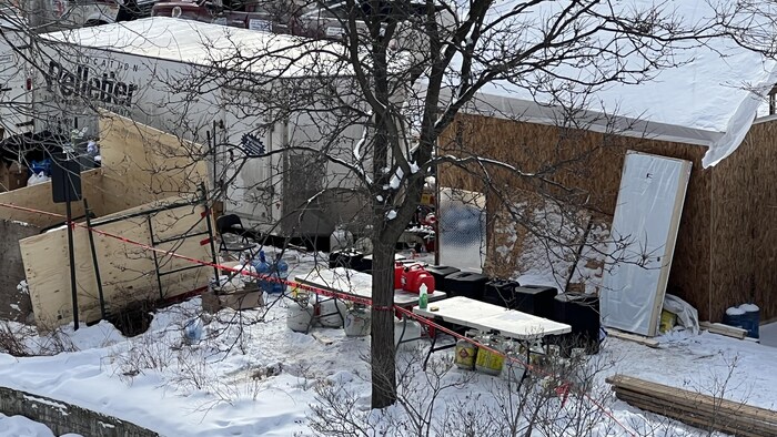 Une cabane en bois dans un parc avec des réservoirs à propane.