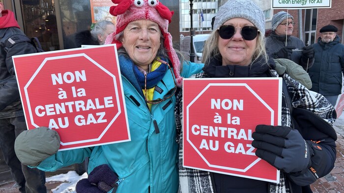 Yoanne Beauséjour-Beauchamps et Danny Dupuis avec chacune une affiche "Non à la centrale au gaz".