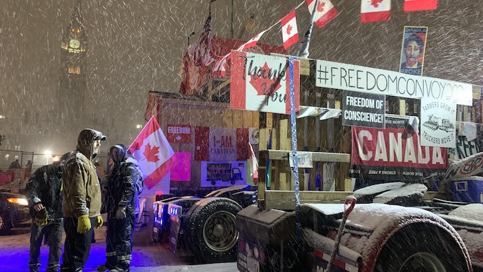 Manifestantes y sus camiones bajo la nieve frente al Parlamento. 