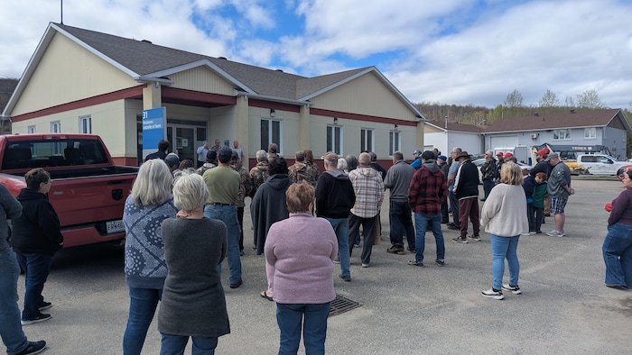 Des citoyens tiennent un rassemblement devant un édifice gouvernemental.  