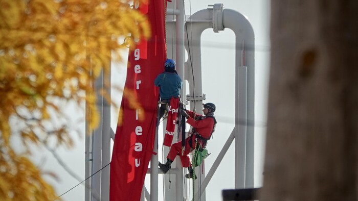 Deux manifestants ayant grimpé sur une tour de chargement pétrolier. 