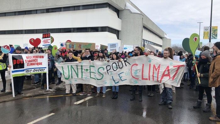 Des étudiants tiennent une banderole sur laquelle on peut lire «Unis pour le climat».