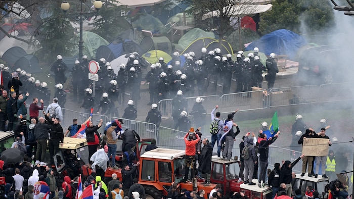 La police et des manifestants séparés par une clôture.