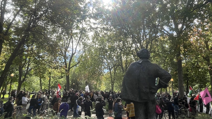 Des manifestants derrière la statue de Féli Leclerc, dans le Parc Lafontaine, à Montréal.