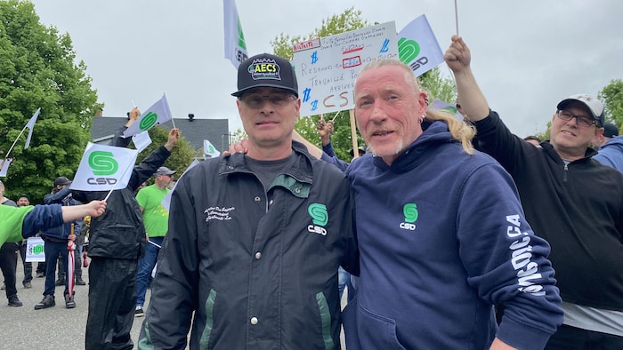 Serge Dufour et Marc Vigneault bras dessus, bras dessous dans une manifestation.