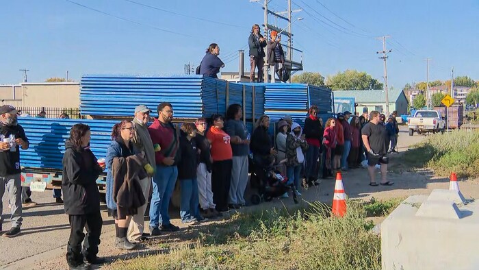 Des manifestants, placés en ligne, protestent contre le démantèlement du campement.