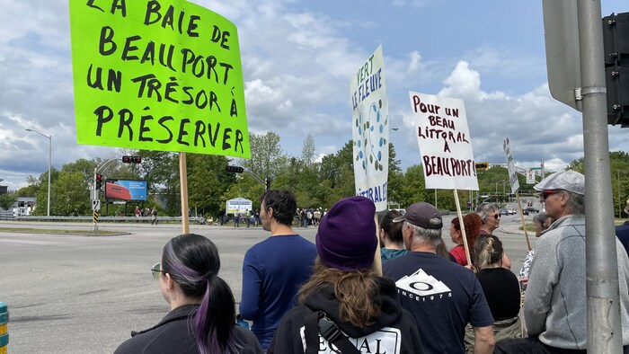 Une dizaine de personnes. Une femme tient une pancarte qui porte la mention «La baie de Beauport, un trésor à préserver».